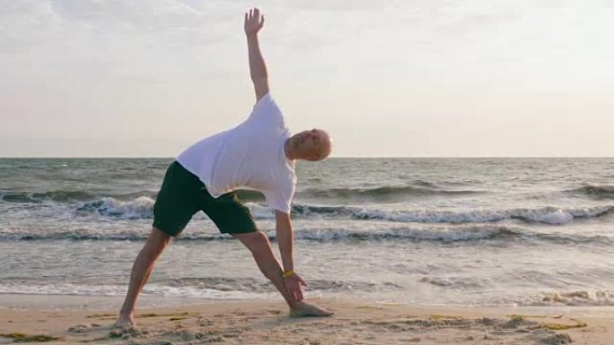 在海边的伸展三角体式练习瑜伽的运动员