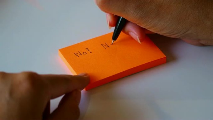 在橙色的便签纸或记事本上手写 “否” 一词