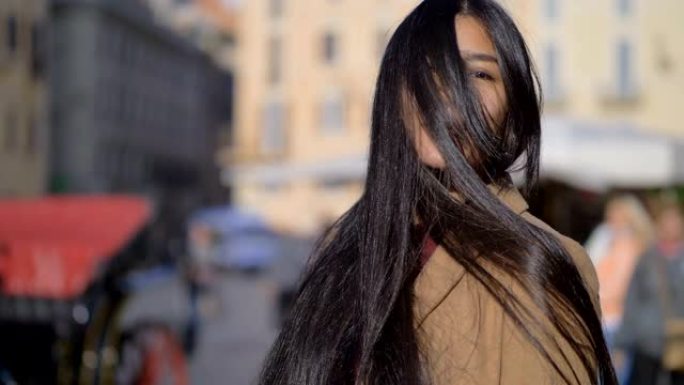 亚洲性感年轻女子转动她的长发-户外-慢动作