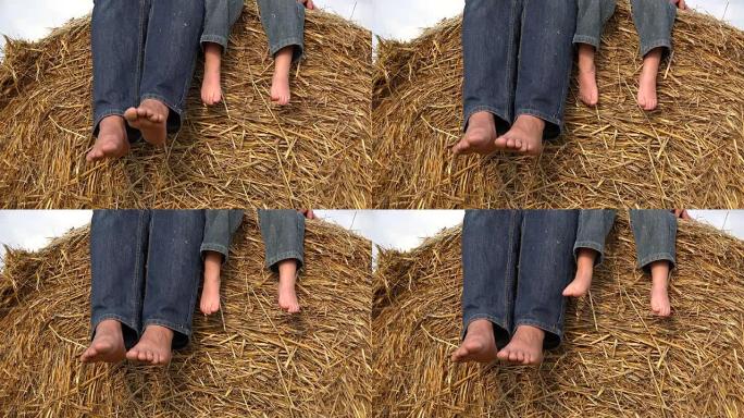 赤脚父母和孩子的脚在干草堆上放松的细节，鞋底在玩耍