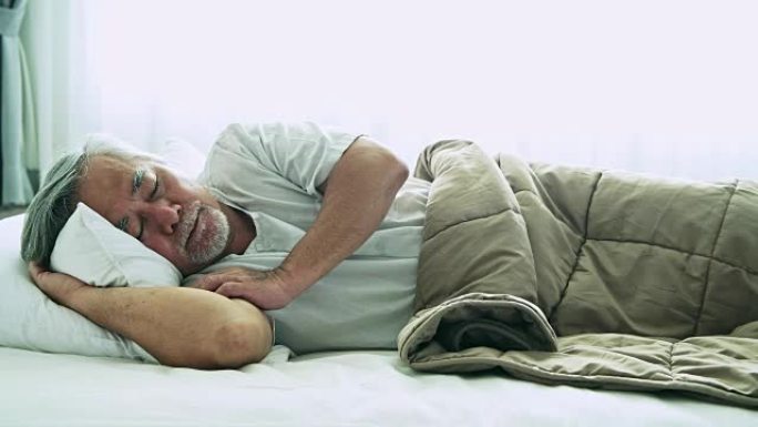 睡在床上的老人。亚洲老人躺在窗帘打开的床上舒适地睡觉。高级生活理念。