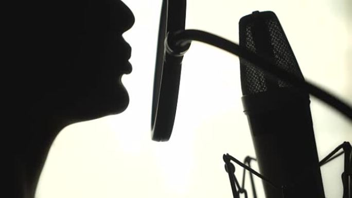一个在录音棚里唱歌的女人的剪影