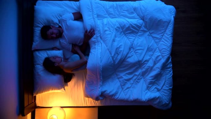 睡在床上的男人和女人。晚上时间