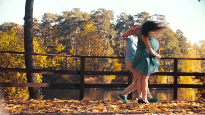 年轻幸福的夫妇在木桥上跳舞