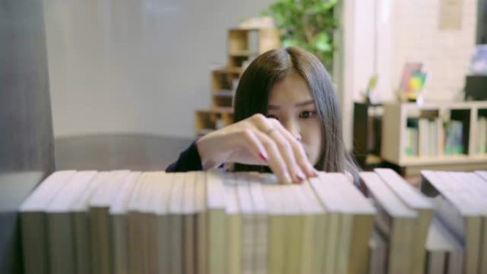 亚洲女学生在大学图书馆看书。教育理念。