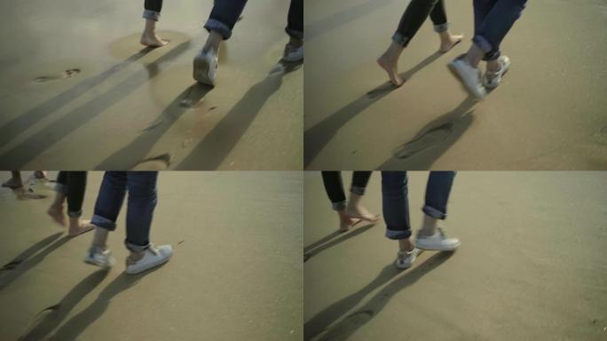 两个人在潮湿的沙滩上行走的短拍。