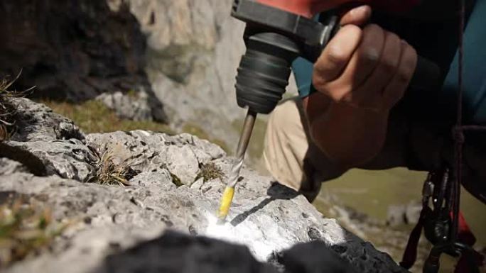 锤子的特写在岩石上钻一个洞。