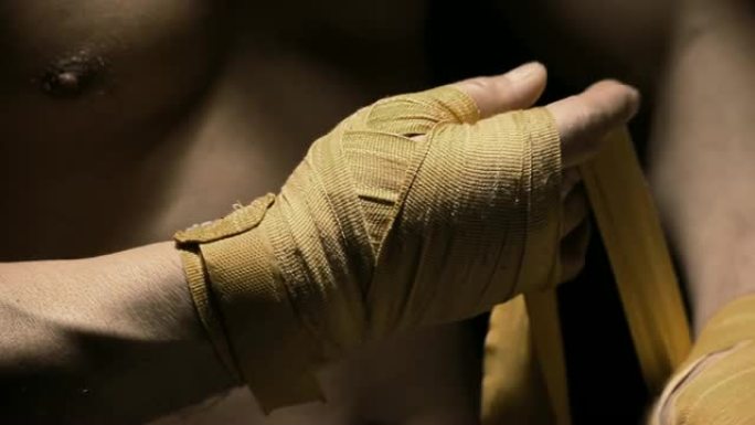 运动员用黄布绑住他的手。特写镜头。