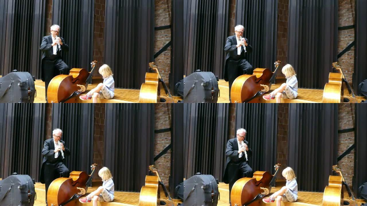 男音乐家正在和他的孙子玩双簧管和低音提琴。