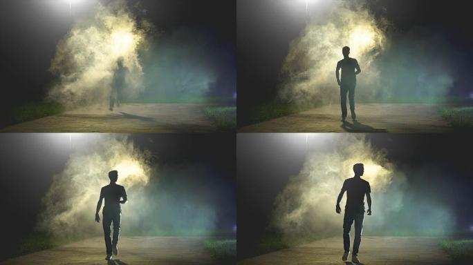 在黑暗背景上的烟雾中奔跑的男人，慢动作