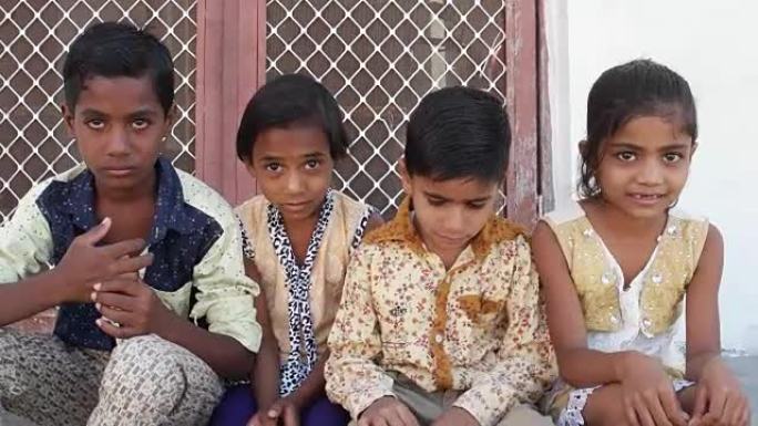 印度孩子低着头，但仍沾沾自喜地微笑着，手持