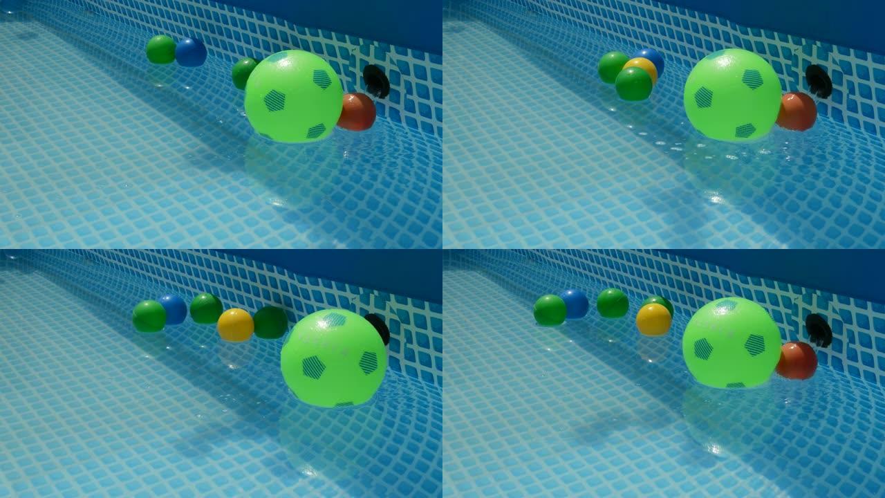 彩球漂浮在一个小的夏季游泳池的水中