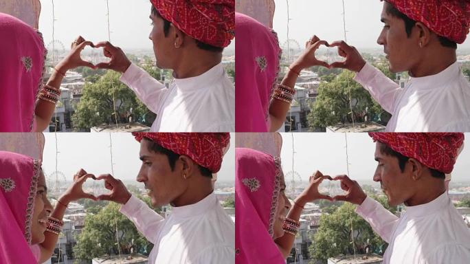 印度拉贾斯坦邦，一对拉贾斯坦邦夫妇在监督普什卡尔梅拉节，他们用手做心形手势