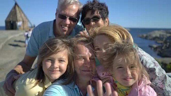 一个幸福的大家庭在海岸上自拍或使用电话视频通话摄像头。