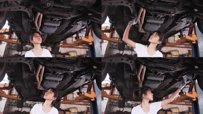 特写平移前视图: 年轻女机械师检查车下的缺陷