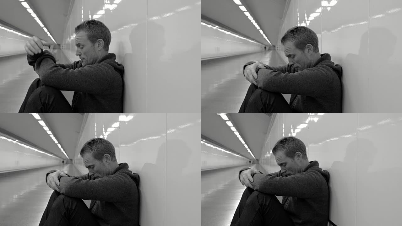 悲惨的失业年轻人哭泣的吸毒者在抑郁中无家可归，压力坐在地面街道地铁隧道上看起来绝望地独自靠在墙上精神