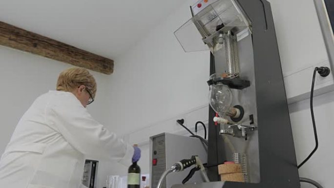 女研究员将白酒倒入葡萄酒提取物蒸馏机器中