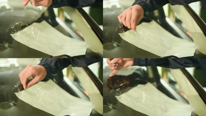 一个专业的人在车间从事消除汽车挡风玻璃上的裂缝的特写镜头。