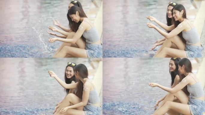 美丽的年轻女子在游泳池放松，快乐的女人泼水
