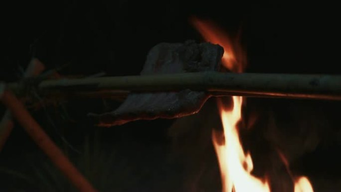 排骨用竹子粘在一起。用火烧烤，晚上在树林里做饭