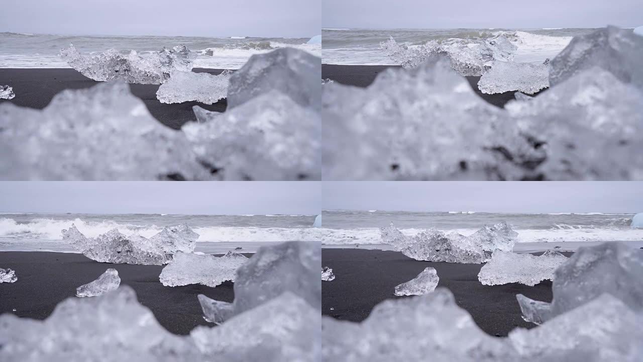在Jokulsarlon Diamond's beach的冰岛黑沙滩上，海浪在冰山上飞溅的4k视频。