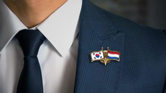 商人带着朋友国家的国旗走向相机，将韩国-荷兰