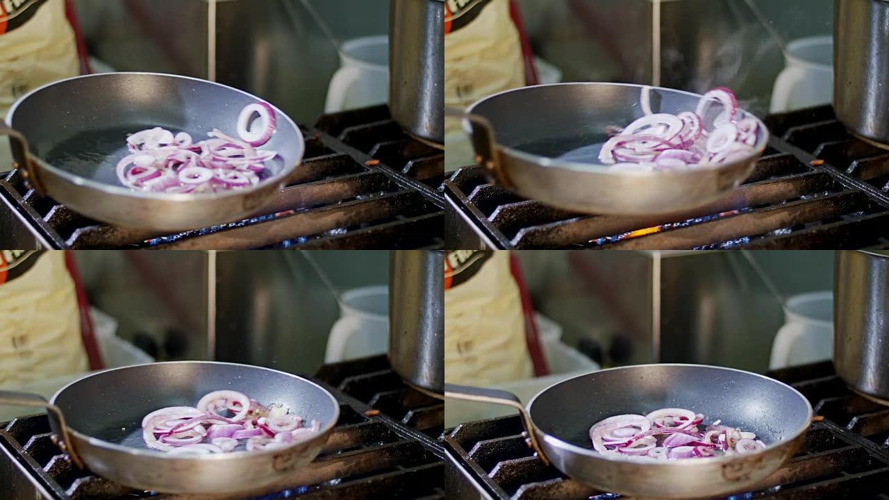 用橄榄油在平底锅上油炸的紫色洋葱