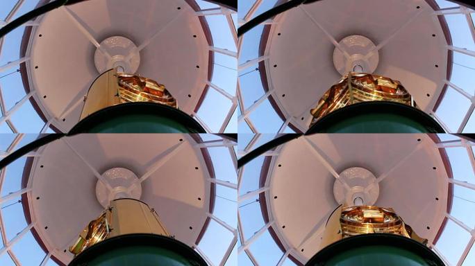灯塔内移动的金色菲涅耳透镜的特写。
