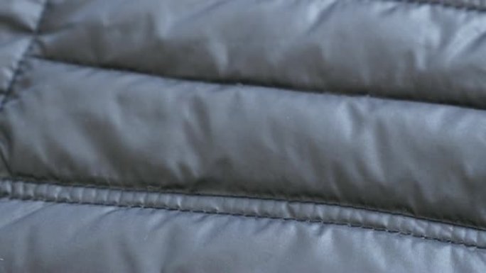 冬季暖风派克大衣合成表面缓慢倾斜4K 2160p 30fps超高清镜头-管壁填充夹克的特写3840X