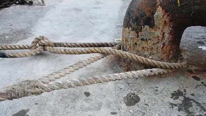 带有打结航海绳索的旧生锈的系泊系缆柱。韩国。