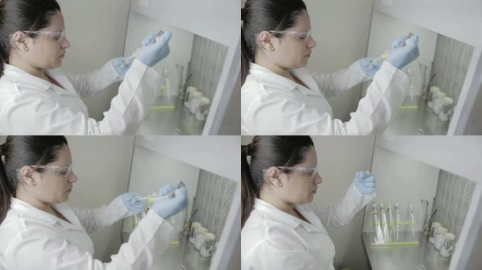 一名研究人员在大学的基因实验室处理样本