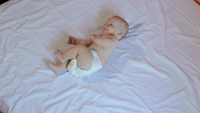 一个可爱的新生婴儿躺在卧室的床上。肖像。
