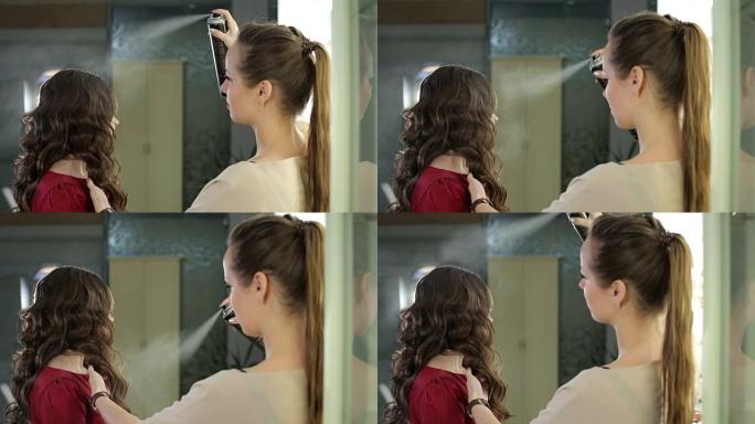 女性造型师在美容院的发型上使用发胶。