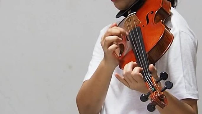 这位女士展示了用手指拨弦的演奏方法，这是小提琴手的Pizzicato技巧。