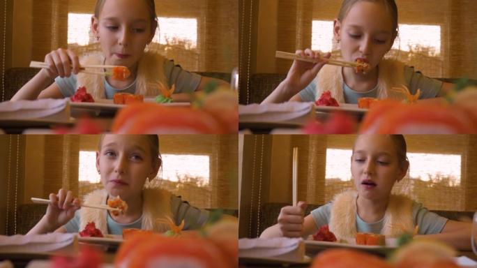 少女口吃寿司配红鲑鱼。用木筷子
