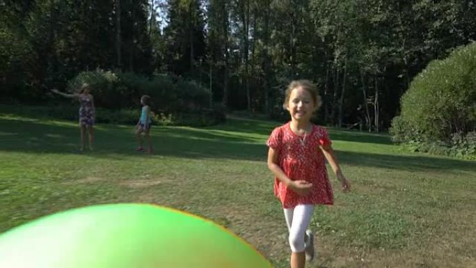 可爱的小女孩玩一个彩色彩虹充气球