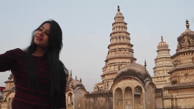 女人在全景吸引人的华丽的寺庙要塞宫殿建筑群前，从一个有利的角度，在更高的水平上用手机相机自拍，游客印