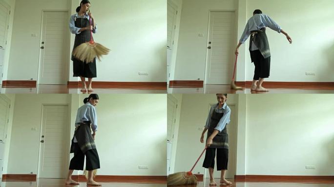 用扫帚棒打扫房子的女人。