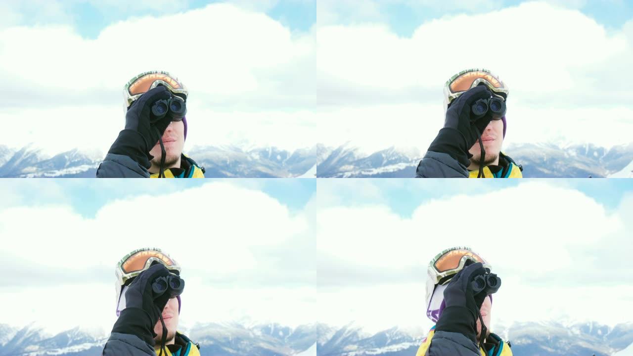 一名戴着滑雪镜的男子通过双筒望远镜望着山脉，欣赏美景，4K