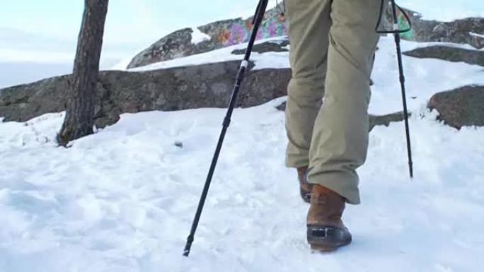 年轻人在山区冬季徒步旅行，背包客在雪地上行走