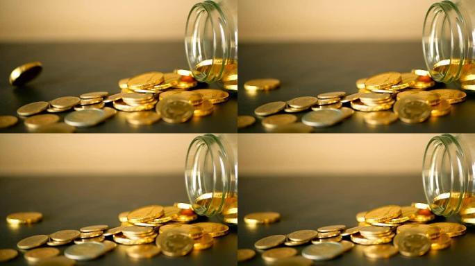 特写静默，黑色桌子上有金币，旋转便士。黄色硬币从罐子里掉了出来。