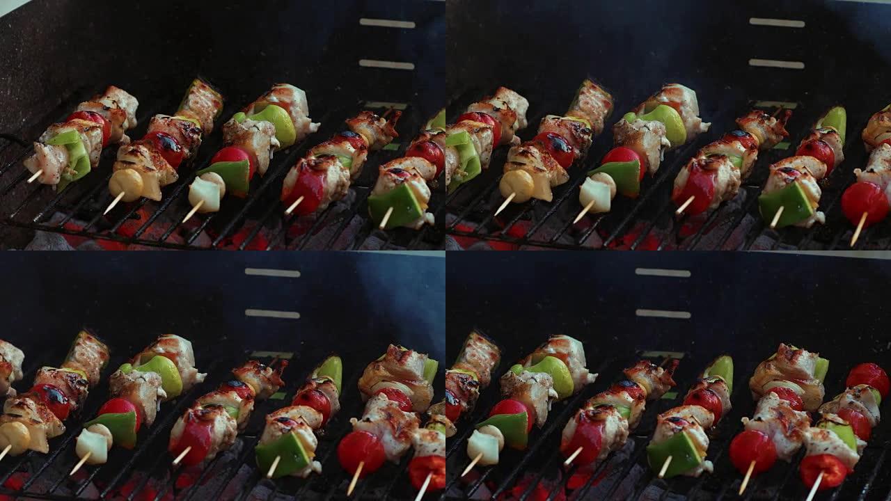 在烧烤架上的竹签上烹饪新鲜蔬菜和腌制的肉，并带有火和吸烟特写