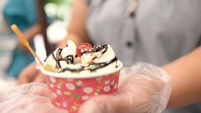 美丽的冰淇淋杯甜点杯由甜美的彩色球制成，街头小贩期间有毛刺焦点，为顾客提供高清