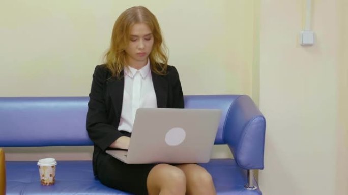 商务妇女坐在沙发上使用笔记本电脑在商务办公室工作
