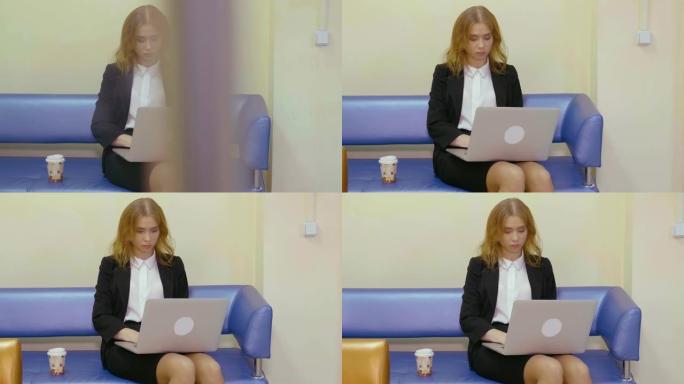 商务妇女坐在沙发上使用笔记本电脑在商务办公室工作