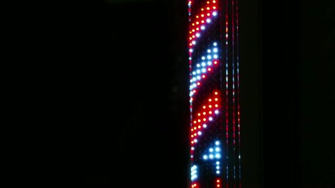 发光二极管灯理发杆夜间旋转。国际理发店杆标志。运动4k镜头