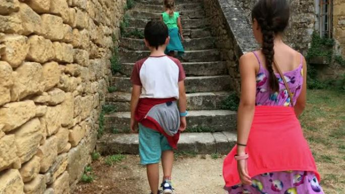 儿童在中世纪村庄走上旧台阶