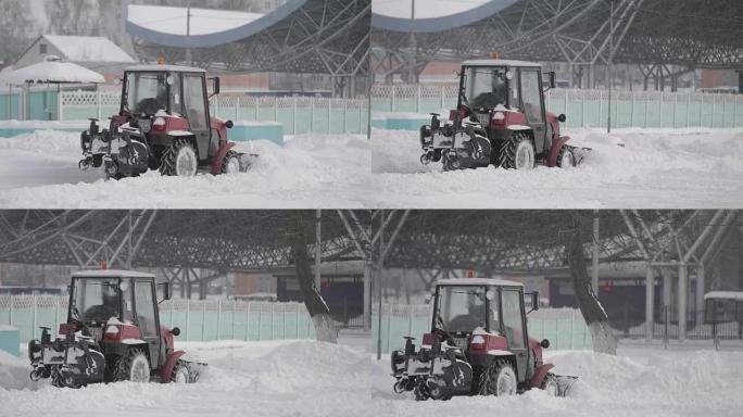 拖拉机在城市的冬天下雪。冬季服务车辆在工作。除雪车