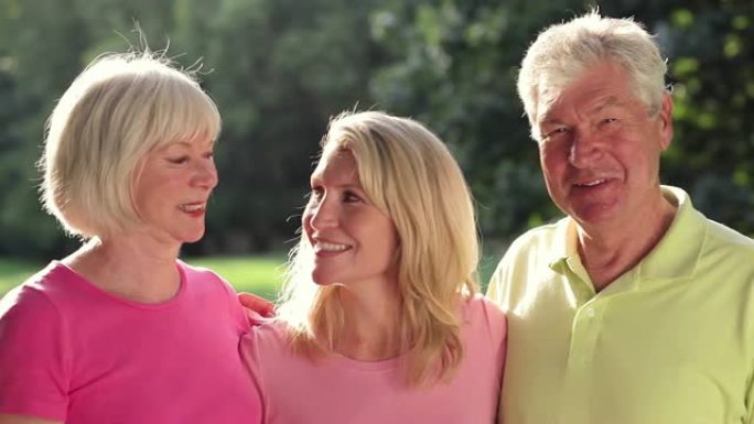 婴儿潮一代和女儿在公园里对着镜头微笑。中枪。