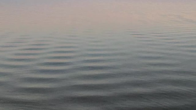 日落背景下湖上的水波纹